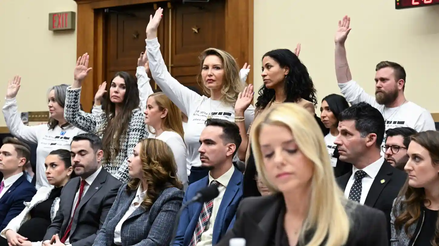 Epstein survivors raising hands during congressional hearing with Pam Bondi testifying