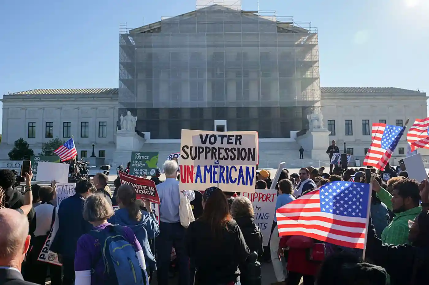 U.S. Supreme Court building exterior with Louisiana state flag and voting rights protest signs